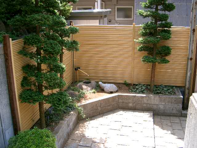 玄関脇に人工の御簾竹と筧を据えて坪庭の作成